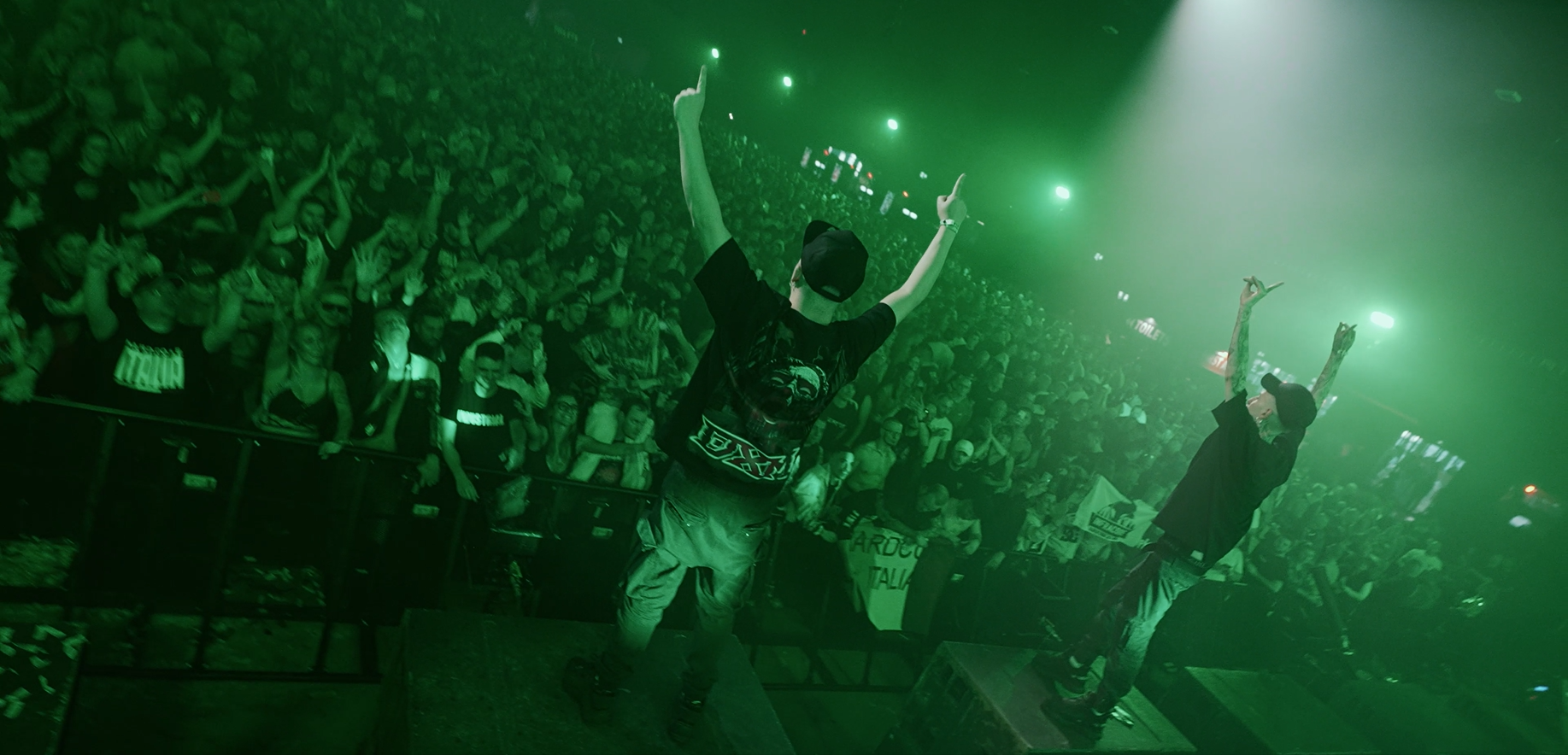 DJ Alien T and Nightshift on stage hyping up a large festival crowd wearing Deus x Machina merchandise